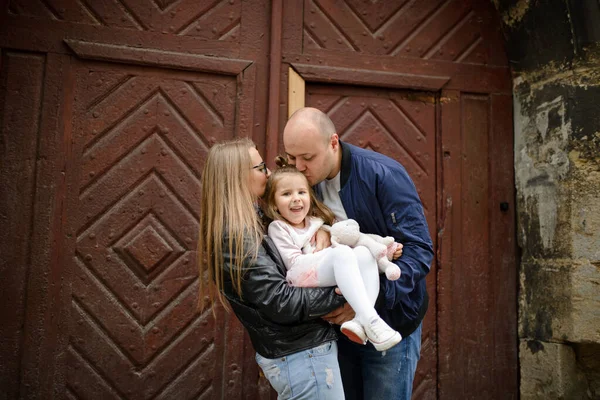 Ouders Houden Een Dochtertje Hun Armen Kussen Haar Neergeschoten Achtergrond — Stockfoto