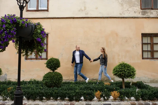 Man Leidt Hand Van Zijn Vrouw Langs Oude Muur — Stockfoto