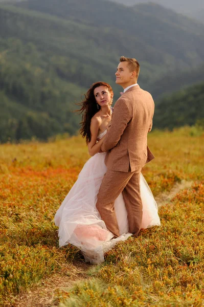Noiva Noivo Estão Abraçados Pôr Sol Foto Casamento Fundo Montanhas — Fotografia de Stock