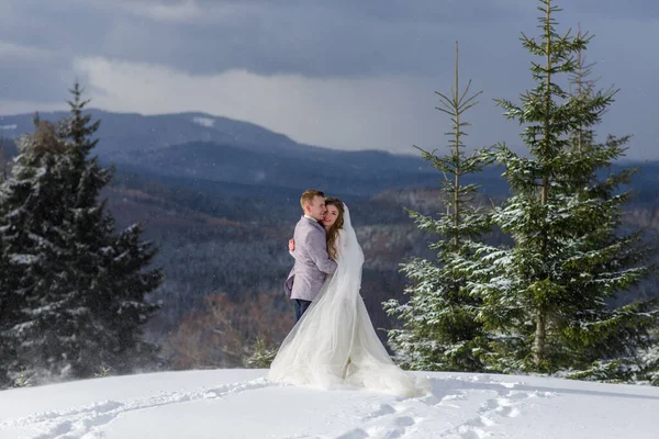Groom Abraça Sua Noiva Contra Pano Fundo Montanhas Cobertas Neve — Fotografia de Stock