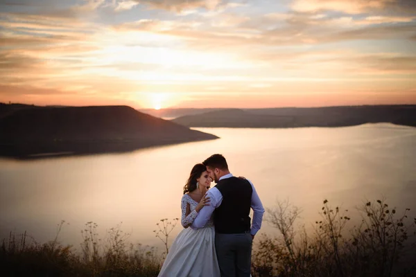 Bruid Bruidegom Knuffelen Achtergrond Van Het Meer Tijdens Zonsondergang — Stockfoto