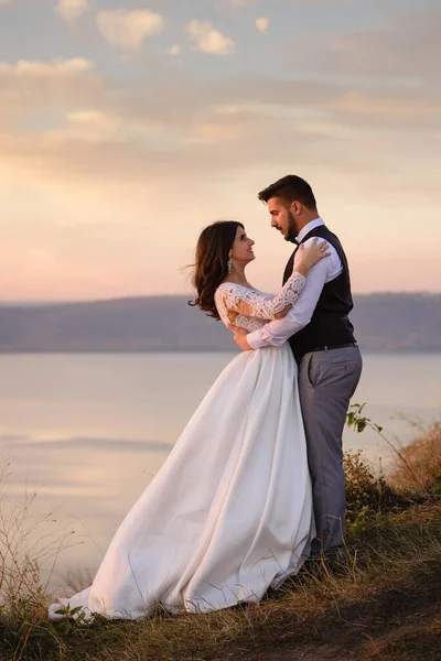 Bruid Bruidegom Knuffelen Achtergrond Van Het Meer Tijdens Zonsondergang — Stockfoto