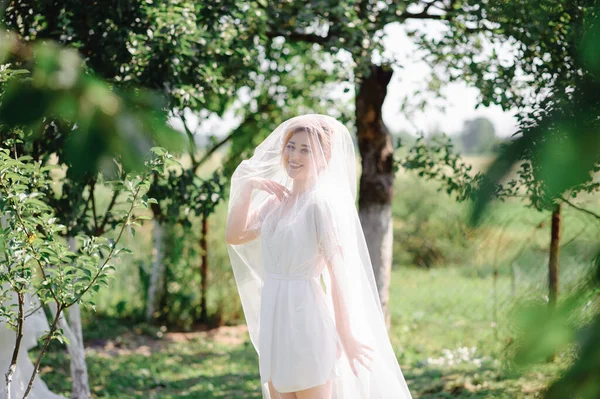 Gyönyörű Szőke Menyasszony Pózol Fátyol Alatt Egy Fürdőköpenyben Egy Zöld — Stock Fotó