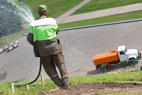 Lavoratore irrigazione prato erba — Foto Stock