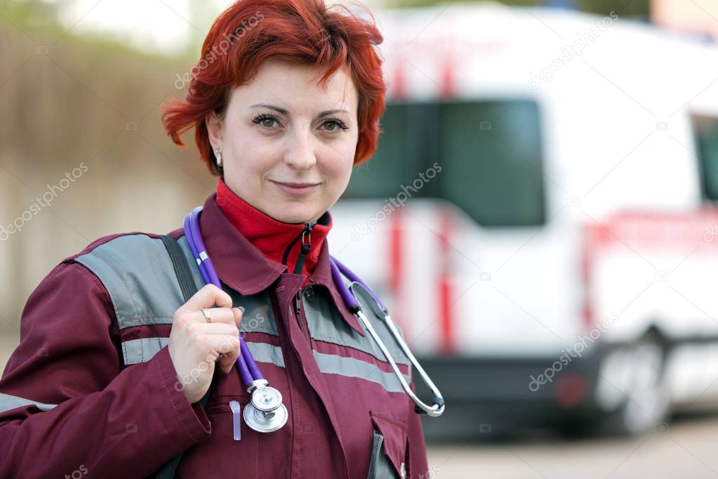 Positive female paramedic with ambulance bag