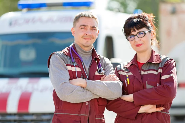 Médico con colega paramédico en el fondo del vehículo ambulancia — Foto de Stock