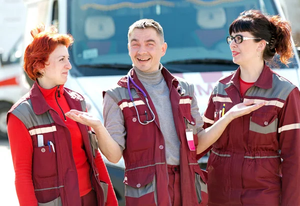 Happy doctor man with smiling paramedics coworker colleague