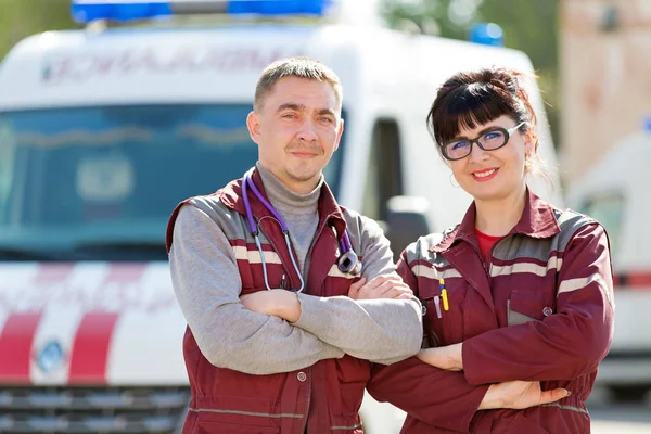 Sonrientes paramédicos en el fondo del coche ambulancia — Foto de Stock