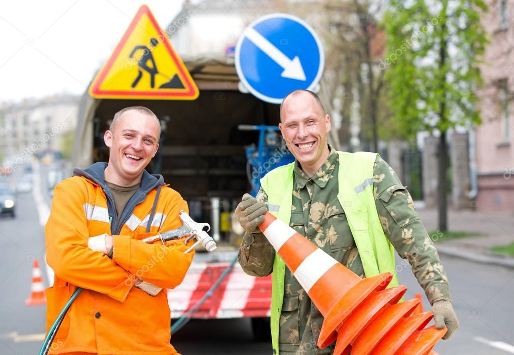Smiling traffic sign marking technician workers