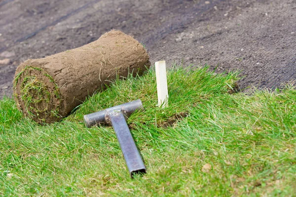 天然芝芝プロをインストールします 固定用の木棒とハンマー ツールは 芝生の再シード時に土壌浸食制御メッシュの Sod を展開 — ストック写真