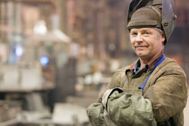 Portre fabrika üst düzey kaynak makinesi işçisi üretim Atölyesi arka plan üzerinde