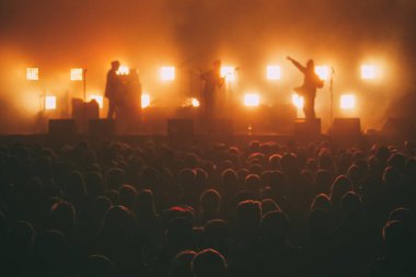 Bir backlights kalabalığın önünde bir sahne rock grubu