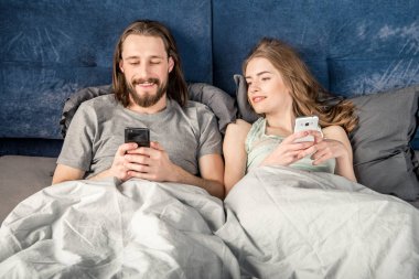 Çift akıllı telefonlar ile yatakta