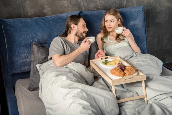 Pareja desayuna en la cama — Foto de Stock
