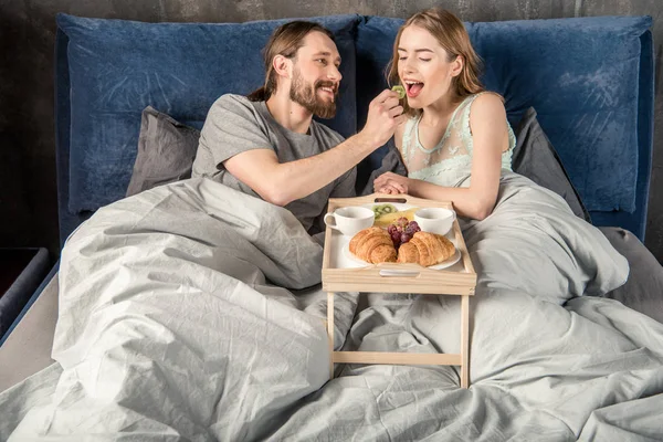 Pareja desayuna en la cama — Foto de Stock