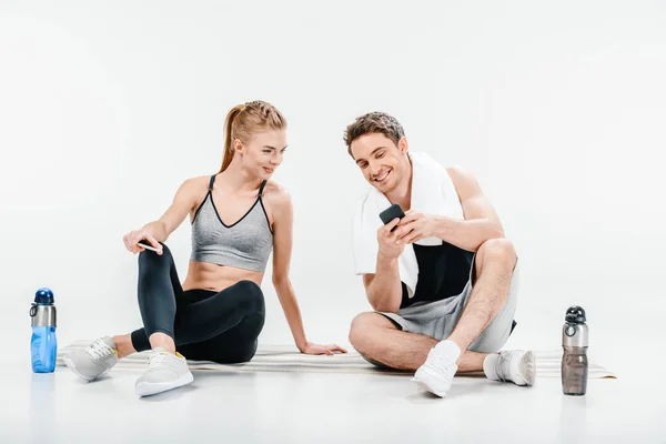 Paret tittar på telefon efter träningspass — Stockfoto