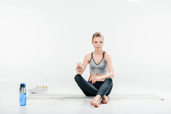 Mulher usando smartphone após o treino — Fotografia de Stock