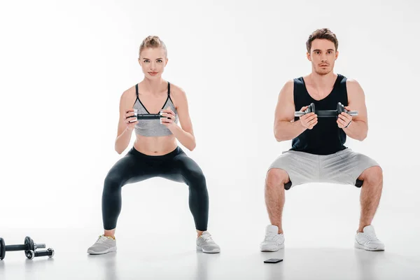 Couple doing squats with dumbbells — Stock Photo, Image