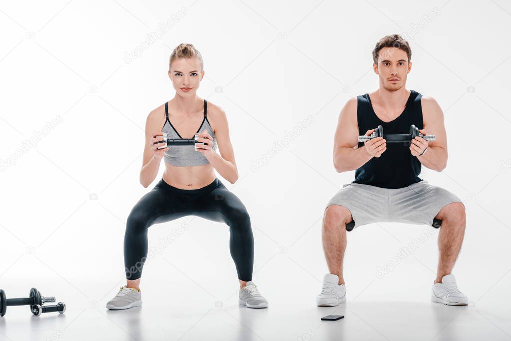 couple doing squats with dumbbells