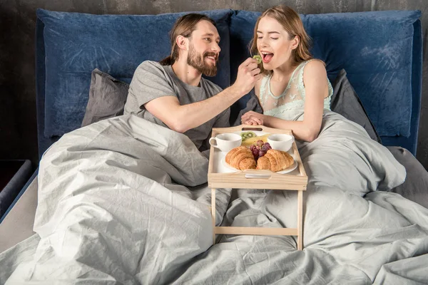 Casal tem café da manhã na cama — Fotografia de Stock