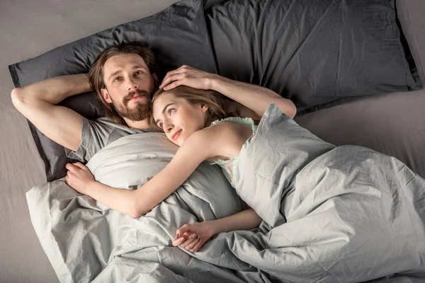 Pareja joven en la cama - foto de stock