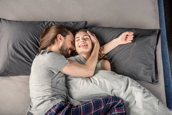 Jeune couple au lit — Photo de stock