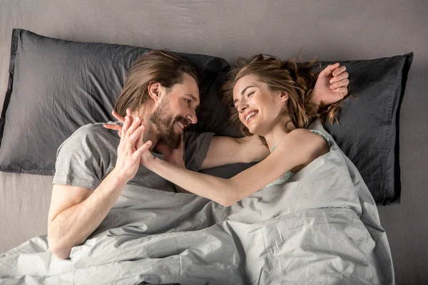 Pareja joven en la cama - foto de stock