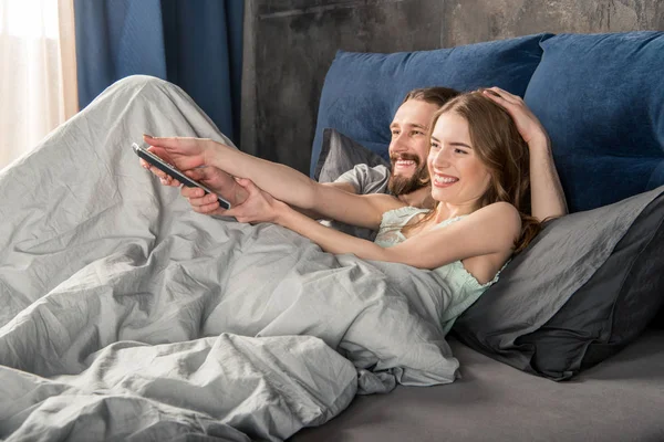 Jeune couple au lit — Photo de stock