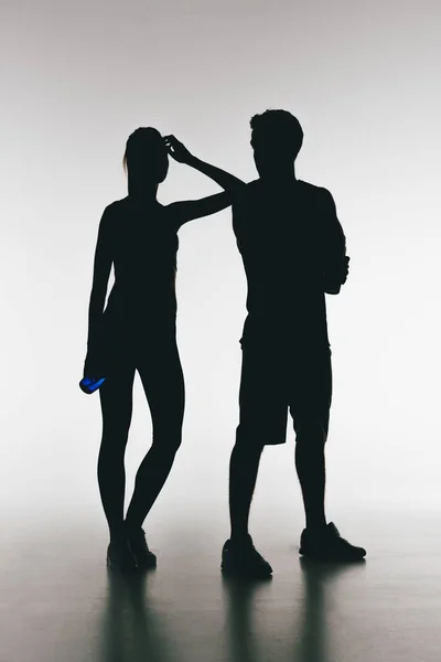 Silhouettes of young fit couple — Stock Photo