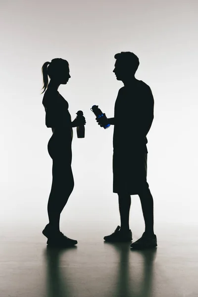 Silhouettes of young fit couple — Stock Photo