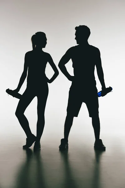 Silhouettes of young fit couple — Stock Photo