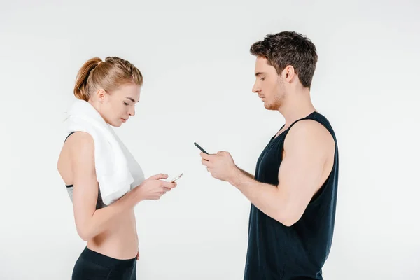 Fittes Paar schaut auf Smartphones — Stockfoto