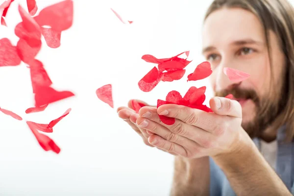 Homem soprando corações de papel — Fotografia de Stock