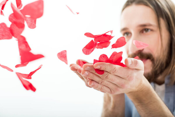 Man blowing paper hearts 