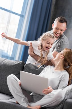 Dizüstü bilgisayar kullanan aile 