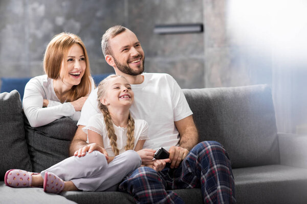 счастливая семья смотрит телевизор
