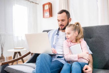 Baba ve kızı dizüstü bilgisayar kullanıyor.