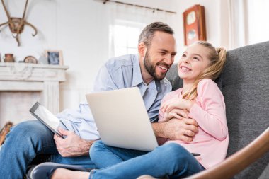 Father and daughter using devices clipart