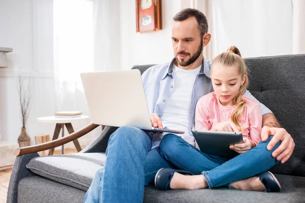 Far och dotter använder enheter — Stockfoto