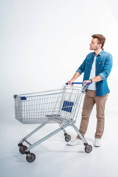 Ung man med shopping vagn — Stockfoto