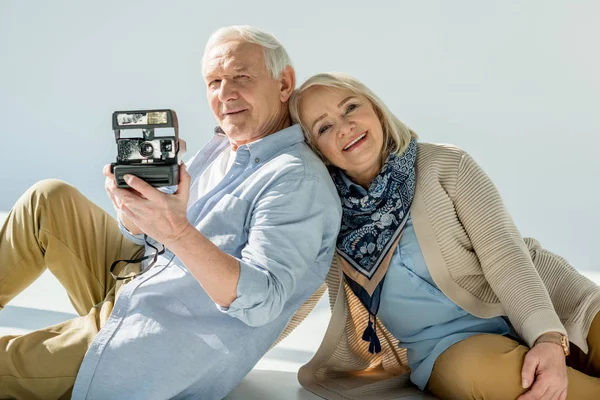 Пожилая пара с ретро камерой — стоковое фото