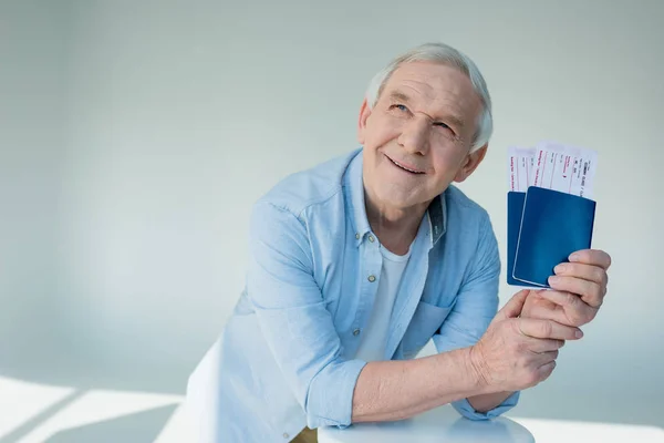 Hombre mayor con pasaportes y billetes — Foto de Stock