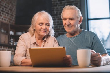 Dijital tablet kullanan yaşlı çift