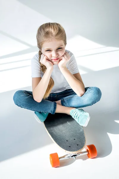 Meisje zit op skateboard — Stockfoto