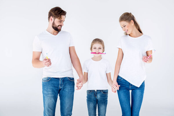 Family holding toothbrushes  