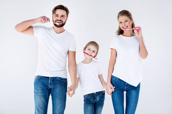 Family holding toothbrushes  
