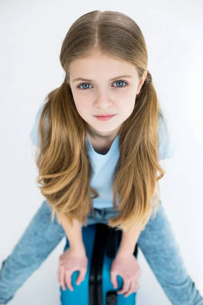 Girl sitting on suitcase — Stock Photo, Image