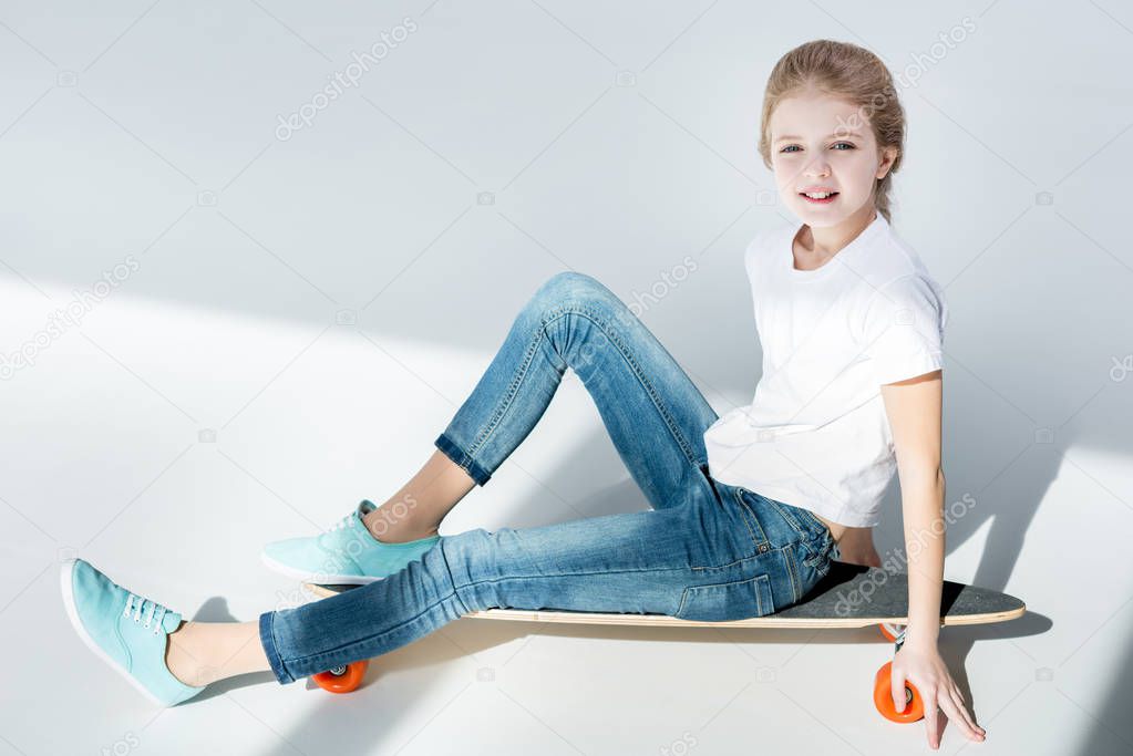 Girl sitting on skateboard 