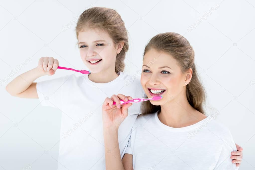 Family holding toothbrushes  