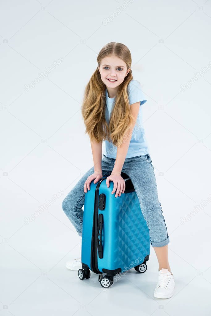 girl sitting on traveling bag